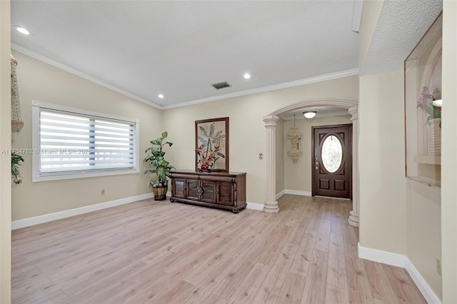 entryway with ornamental molding, light hardwood / wood-style floors, and a healthy amount of sunlight