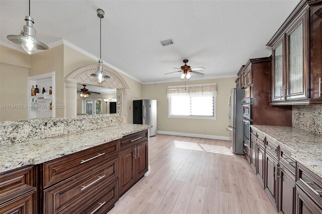 kitchen with stainless steel refrigerator, ornamental molding, and dark brown cabinets