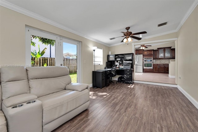 living room featuring dark wood-type flooring, ceiling fan, and ornamental molding