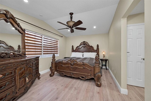 bedroom featuring light hardwood / wood-style flooring, ceiling fan, vaulted ceiling, and a textured ceiling