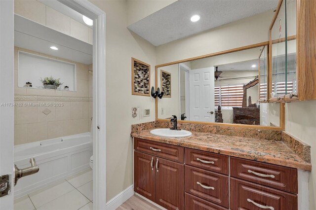 bathroom featuring ceiling fan, vanity, toilet, and tile patterned flooring