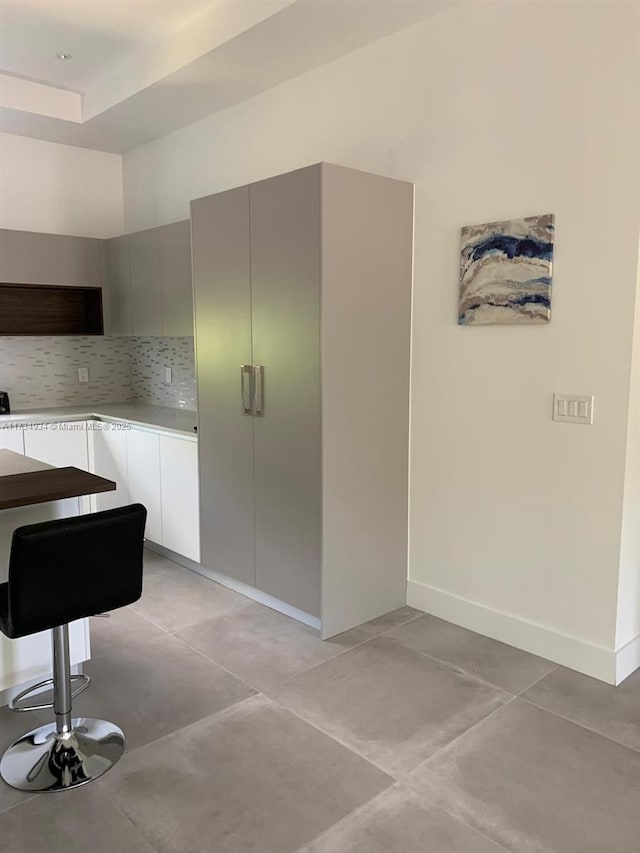 kitchen featuring light tile patterned flooring and backsplash