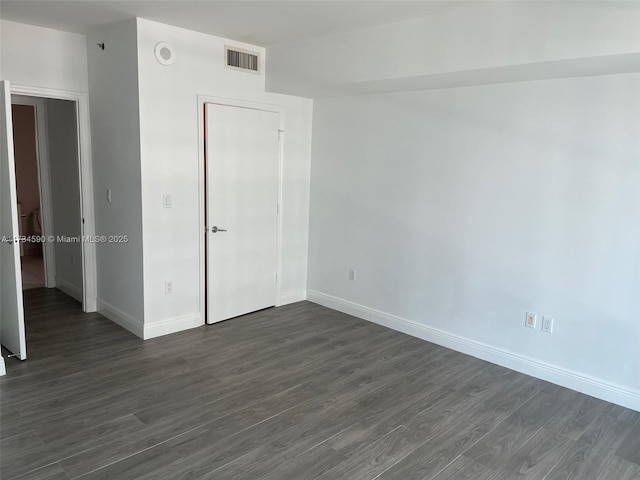 spare room with dark hardwood / wood-style flooring