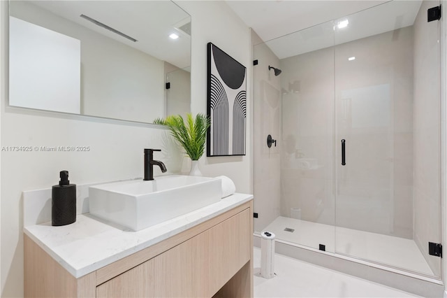 bathroom featuring vanity and a shower with door