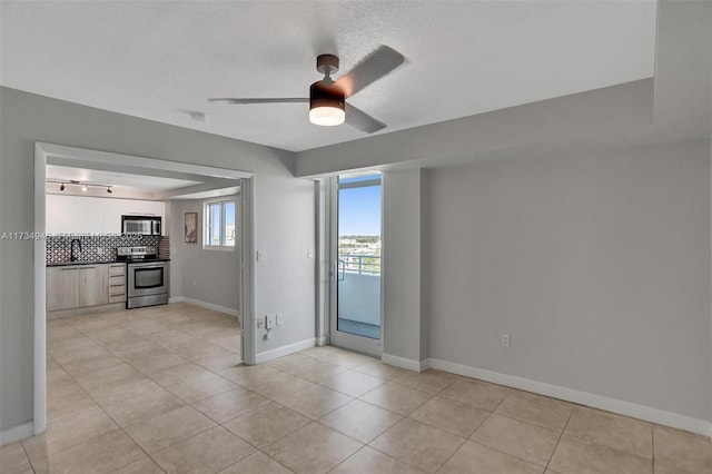 unfurnished room with a textured ceiling, ceiling fan, and light tile patterned flooring