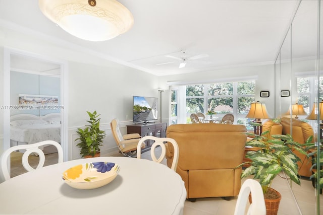 tiled dining space with crown molding and ceiling fan