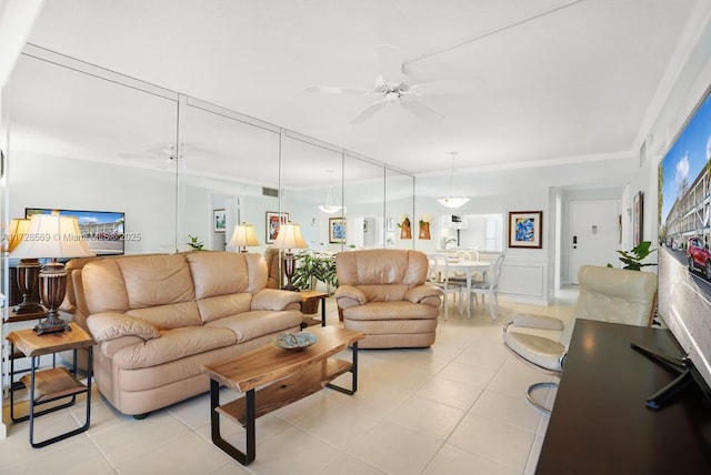 living room featuring light tile patterned flooring, ornamental molding, and ceiling fan