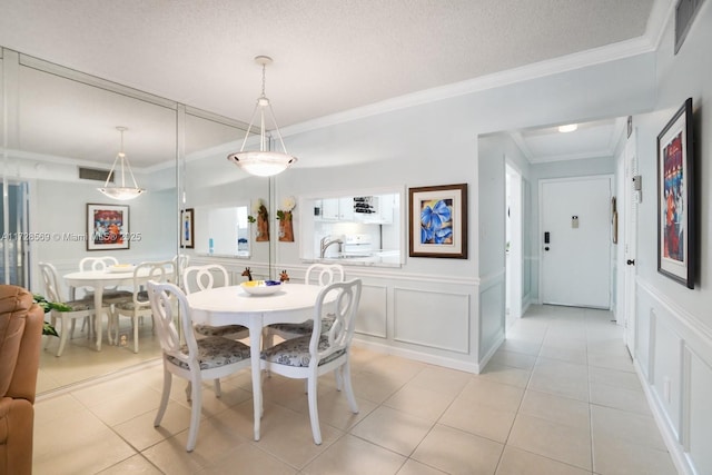 dining area with ornamental molding, light tile patterned floors, and a textured ceiling