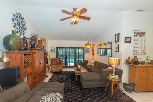 tiled living room with vaulted ceiling, ceiling fan, a textured ceiling, and french doors