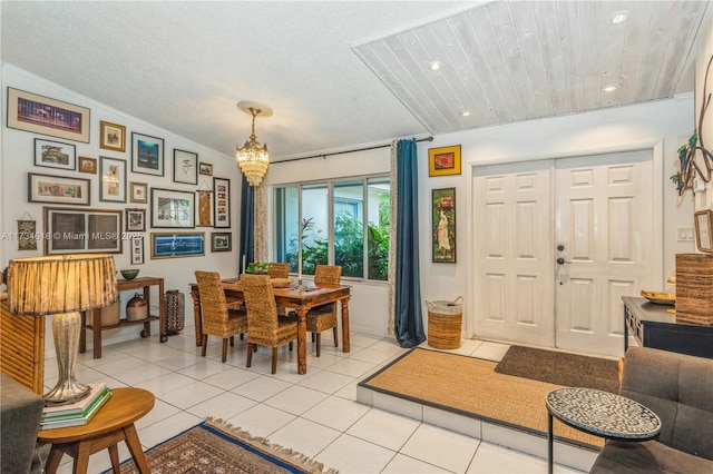 tiled dining room featuring crown molding, a chandelier, and a textured ceiling