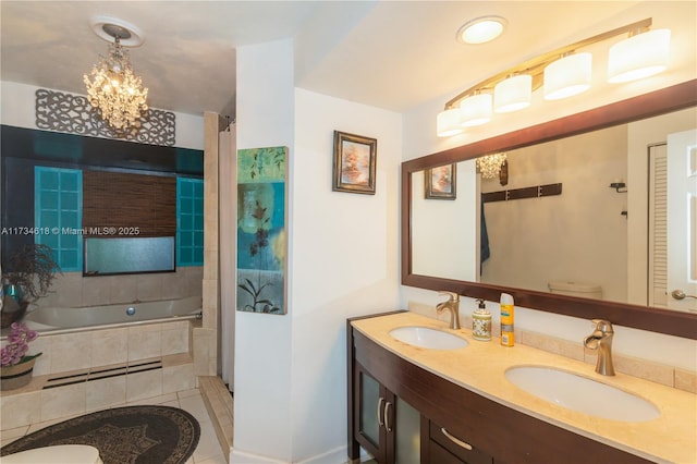 bathroom with toilet, an inviting chandelier, vanity, tiled bath, and tile patterned flooring