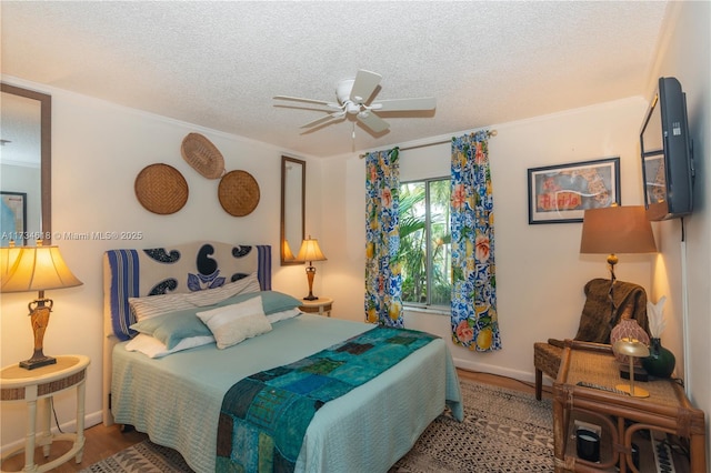 bedroom featuring ceiling fan, crown molding, hardwood / wood-style floors, and a textured ceiling