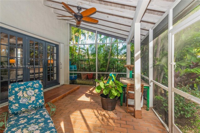 sunroom featuring lofted ceiling with beams and ceiling fan