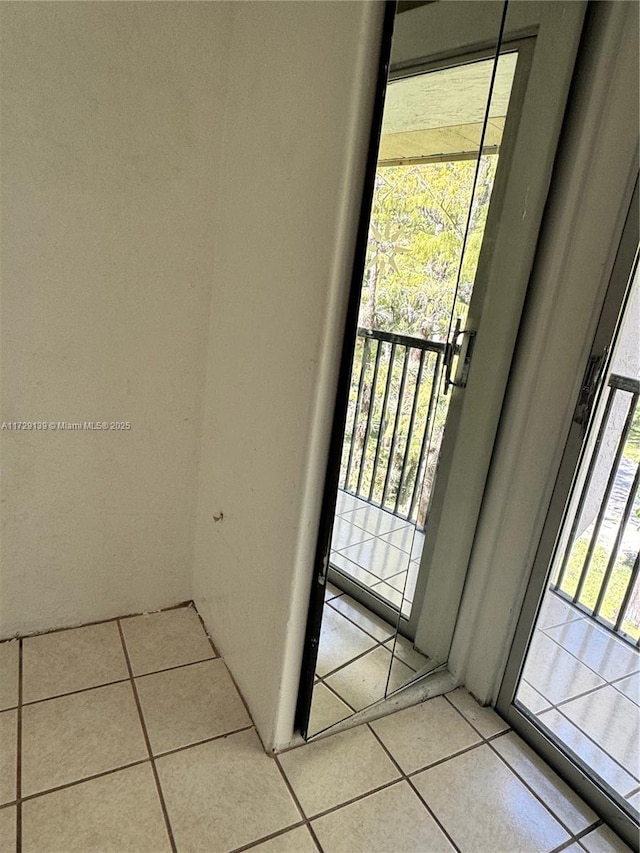 doorway to outside with light tile patterned floors