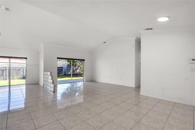 tiled spare room with vaulted ceiling, ornamental molding, and a healthy amount of sunlight