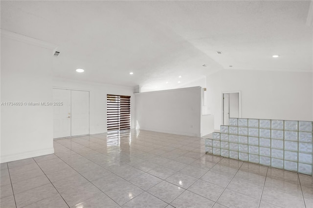 unfurnished room with light tile patterned floors and vaulted ceiling