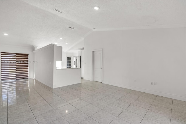 empty room featuring crown molding, light tile patterned flooring, vaulted ceiling, and a textured ceiling