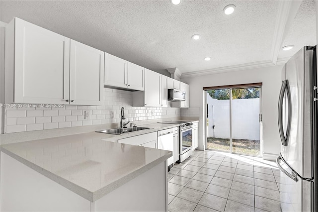 kitchen with sink, appliances with stainless steel finishes, backsplash, white cabinets, and kitchen peninsula