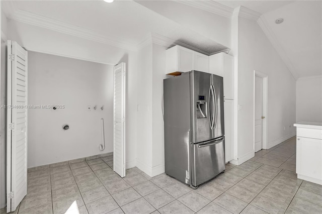 kitchen featuring stainless steel fridge, ornamental molding, white cabinets, and light tile patterned flooring