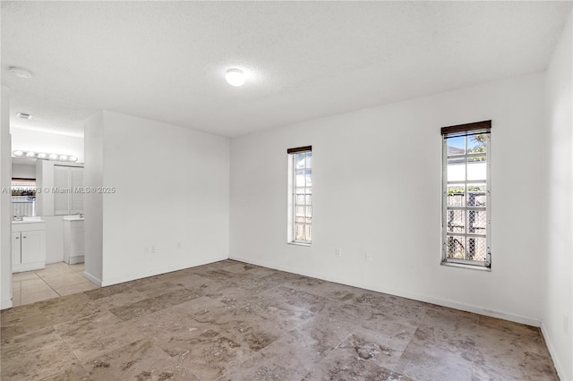 empty room with a healthy amount of sunlight and a textured ceiling