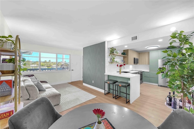 living area with light wood-type flooring and visible vents