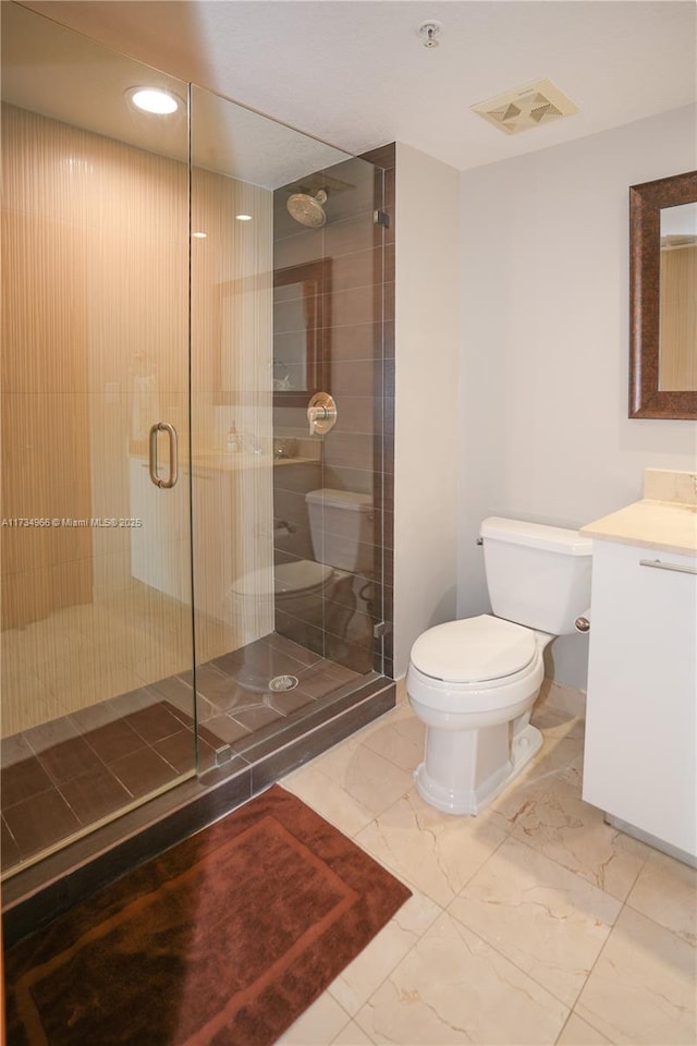 bathroom with vanity, toilet, and a shower with door