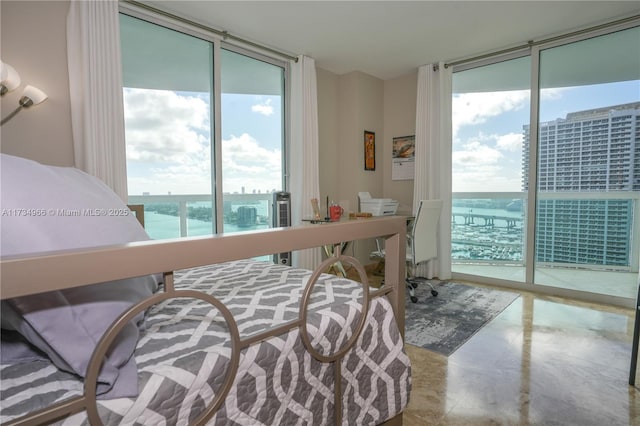 bedroom featuring access to exterior, floor to ceiling windows, and a water view