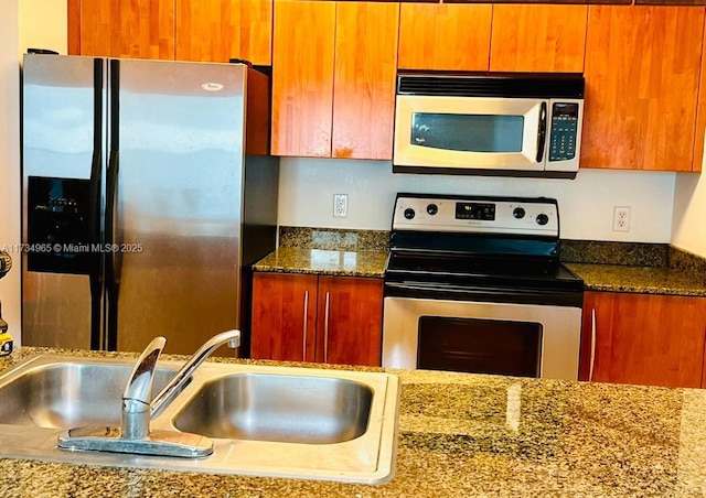 kitchen with stainless steel appliances, sink, and stone counters