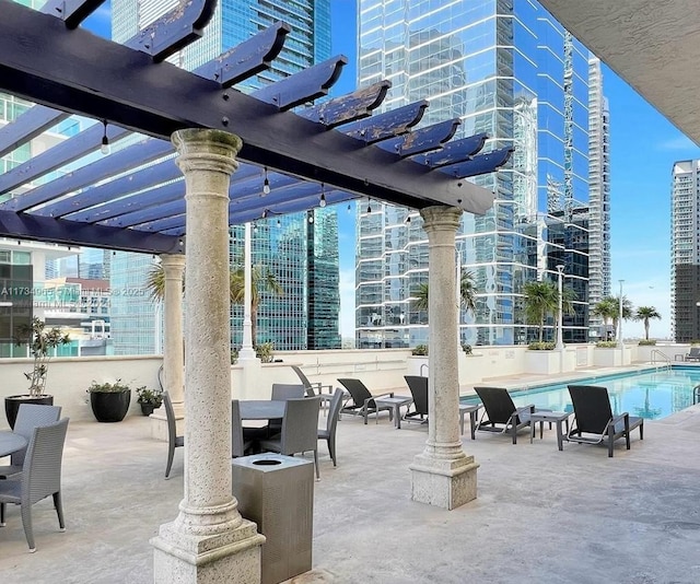 view of patio with a community pool and a pergola