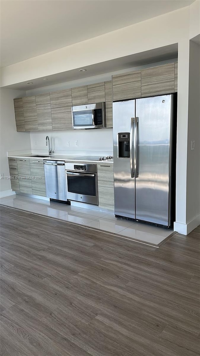 kitchen featuring appliances with stainless steel finishes, dark hardwood / wood-style flooring, and sink