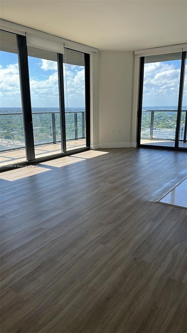 spare room with dark wood-type flooring and a wall of windows