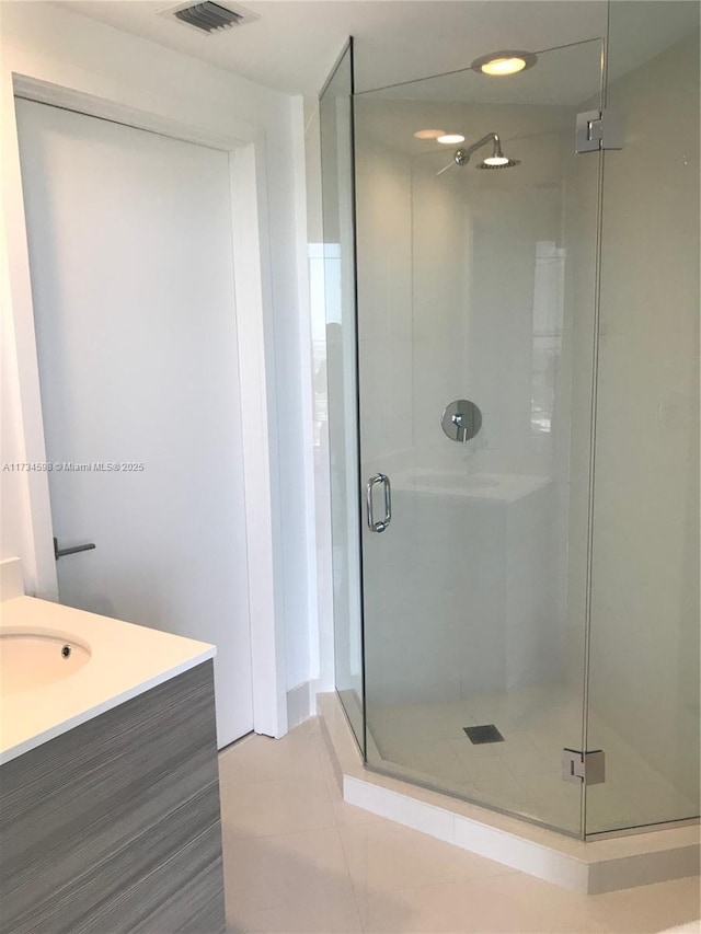 bathroom with vanity, tile patterned flooring, and walk in shower