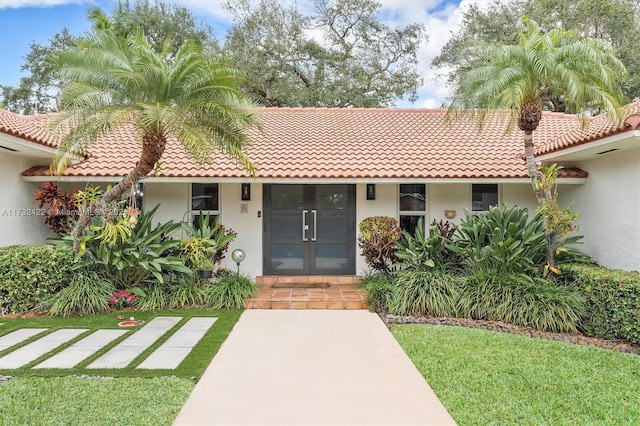 view of front of property featuring french doors and a front lawn