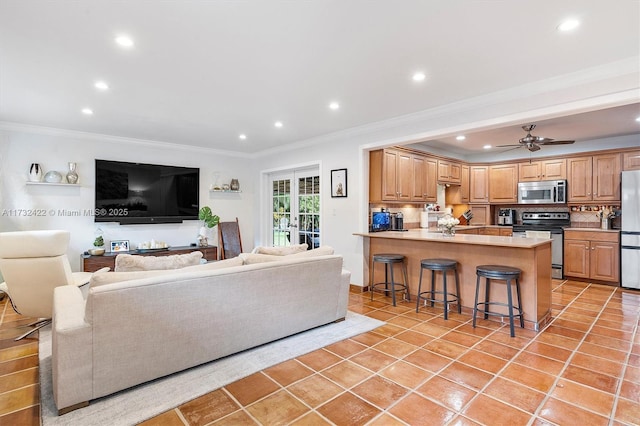 tiled living room with crown molding and ceiling fan