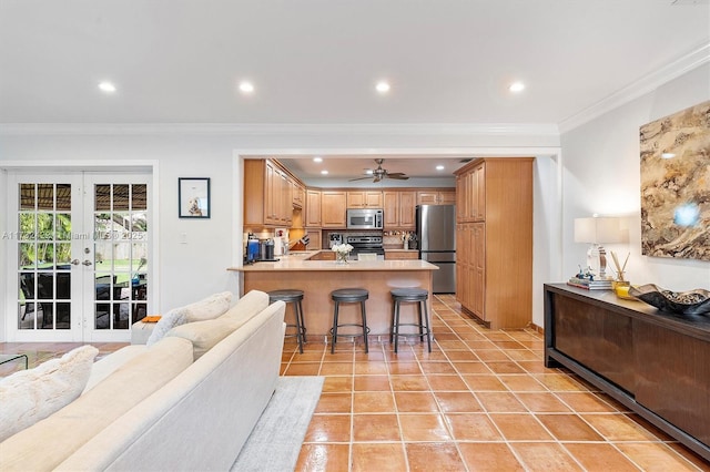 kitchen featuring a kitchen breakfast bar, ornamental molding, light tile patterned floors, kitchen peninsula, and stainless steel appliances