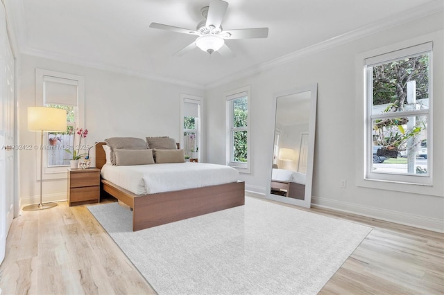 bedroom with ornamental molding, multiple windows, and light hardwood / wood-style flooring