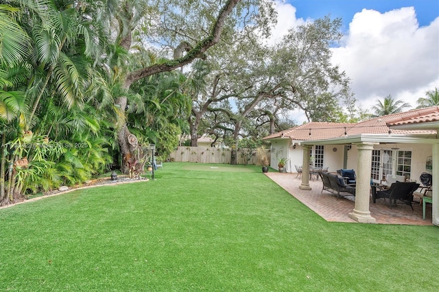 view of yard featuring a patio and french doors