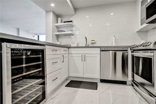 kitchen featuring stainless steel appliances, wine cooler, white cabinets, and decorative backsplash