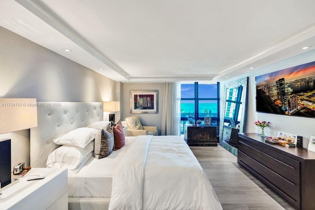 1121 Crandon Blvd Unit D706, Key Biscayne, FL 33149 - bedroom featuring light wood-type flooring, a wall of windows, a tray ceiling, and recessed lighting