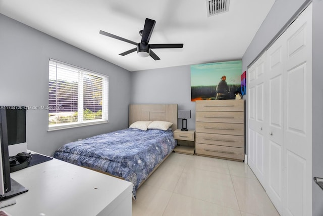 tiled bedroom featuring ceiling fan and a closet