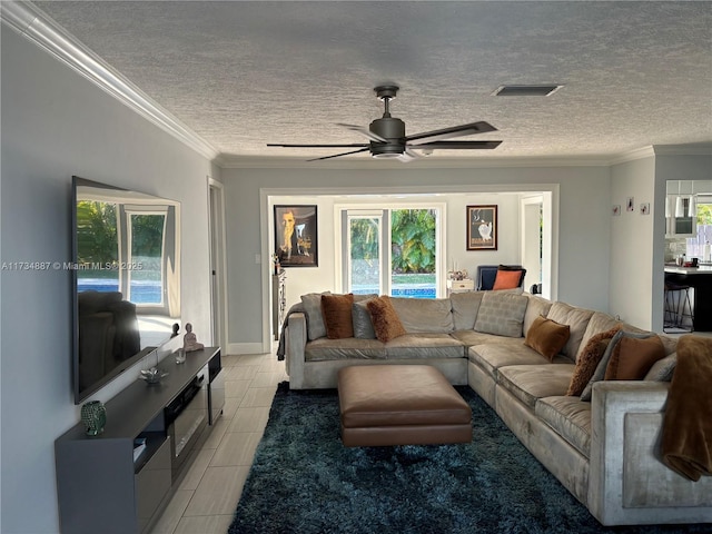 tiled living room featuring crown molding, ceiling fan, and a textured ceiling