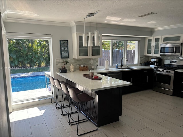 kitchen with white cabinetry, appliances with stainless steel finishes, a kitchen bar, and kitchen peninsula