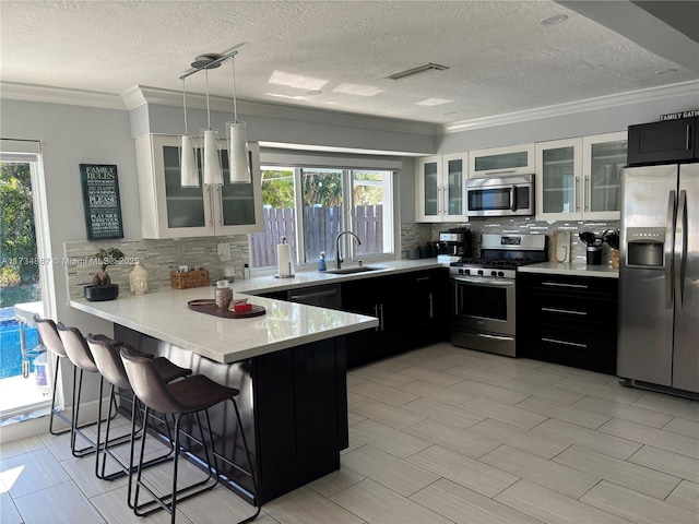 kitchen featuring white cabinetry, sink, a breakfast bar area, kitchen peninsula, and stainless steel appliances