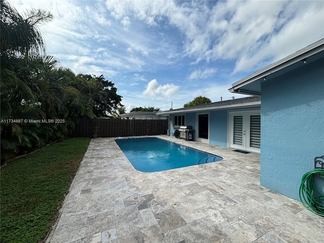 view of pool featuring a grill, a patio area, and french doors