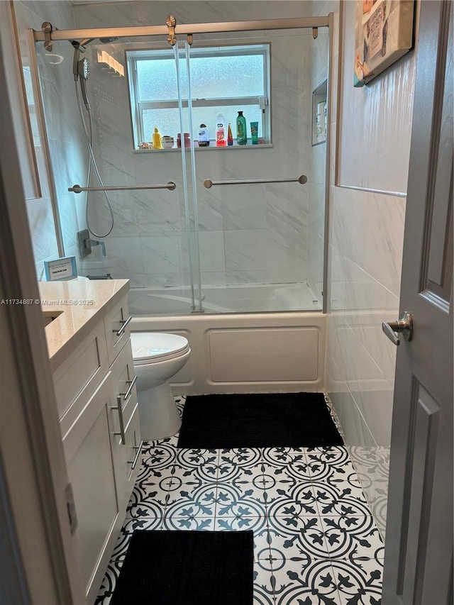 full bathroom featuring tile patterned floors, vanity, toilet, and combined bath / shower with glass door