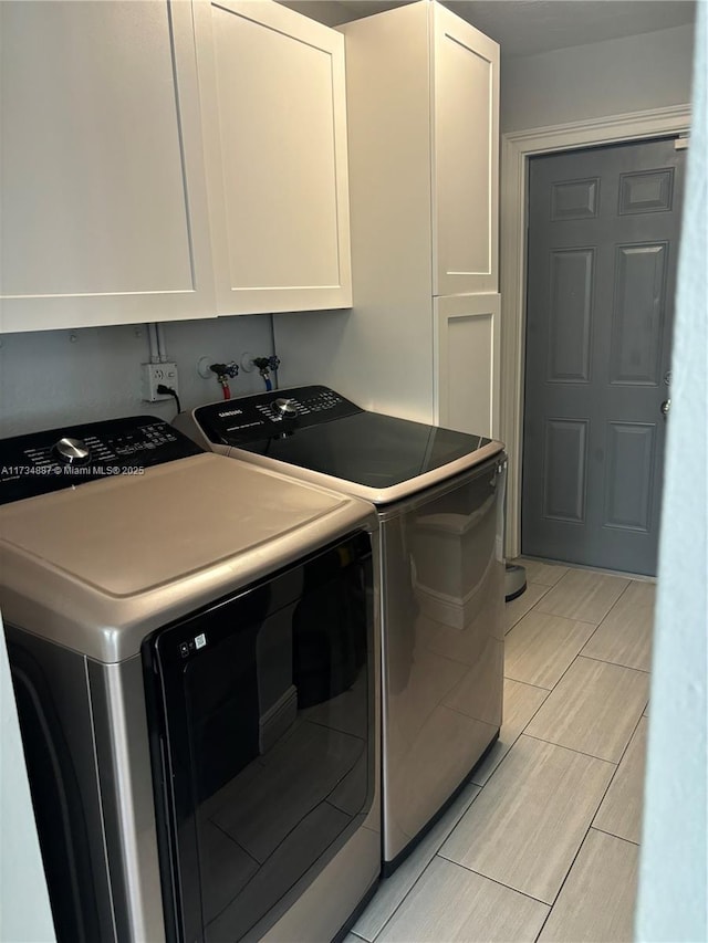 clothes washing area featuring cabinets and washing machine and dryer