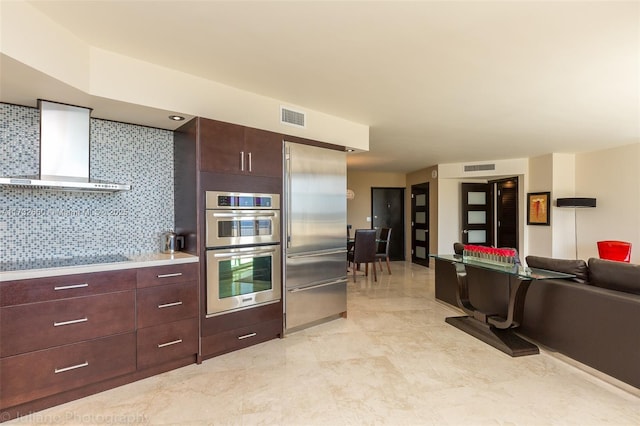 kitchen with stainless steel appliances, wall chimney range hood, and decorative backsplash