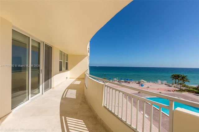 balcony with a water view and a beach view