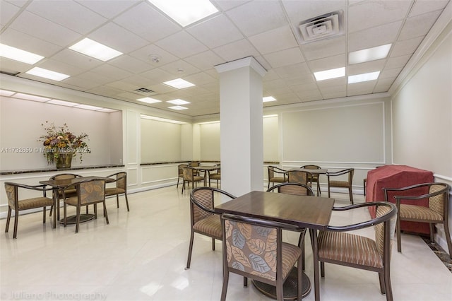 dining room featuring decorative columns, ornamental molding, and a paneled ceiling