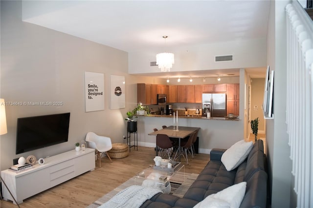 living room featuring an inviting chandelier and light hardwood / wood-style flooring